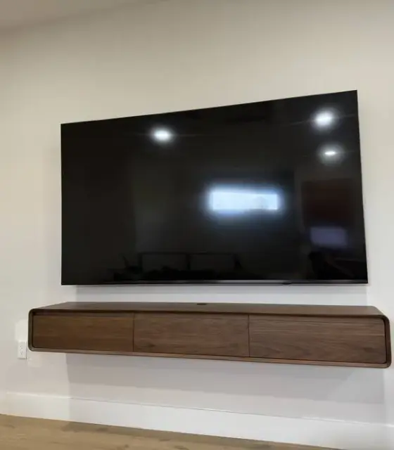 TV mounted above a floating console by Haul Hunters